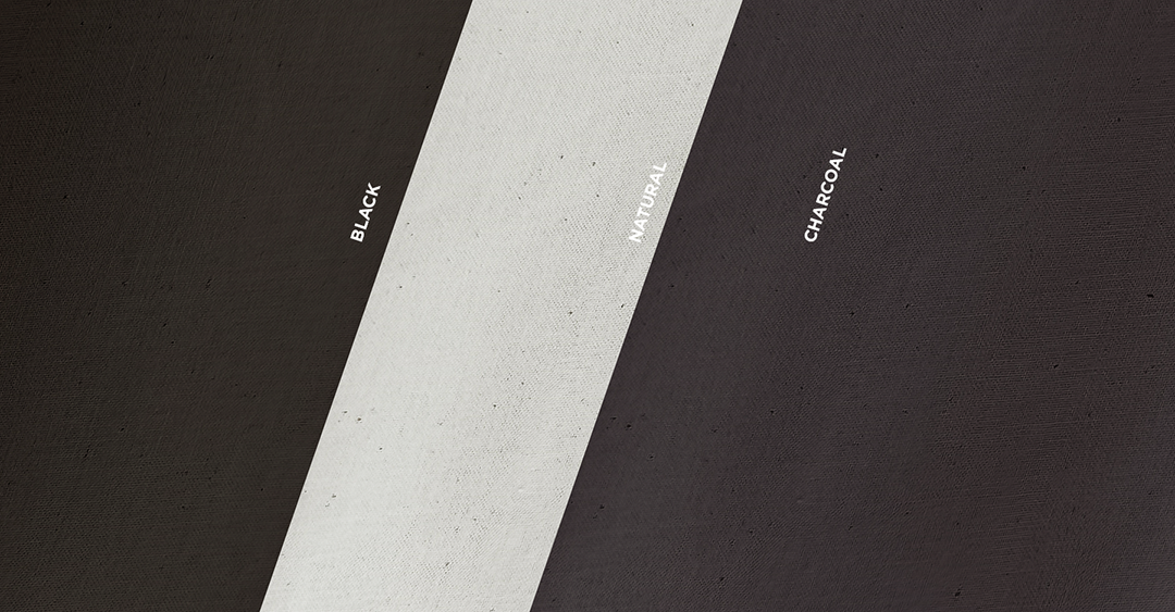 Three colors of organic cotton sheeting fabric including black, charcoal and natural. The fabric swatches are laid one on top of the other at an angle.