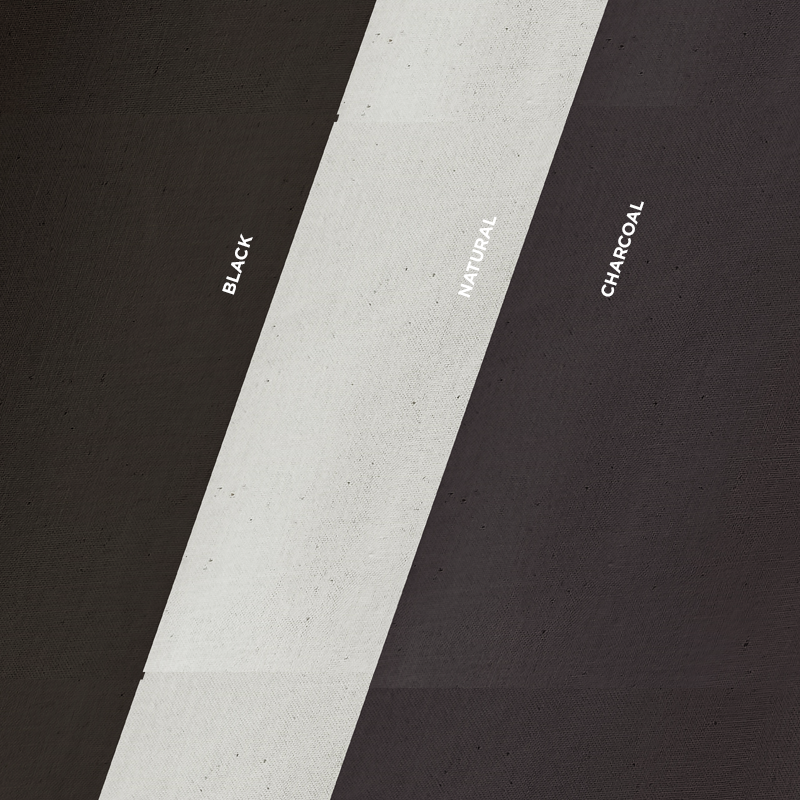Three colors of organic cotton sheeting fabric including black, charcoal and natural. The fabric swatches are laid one on top of the other at an angle.
