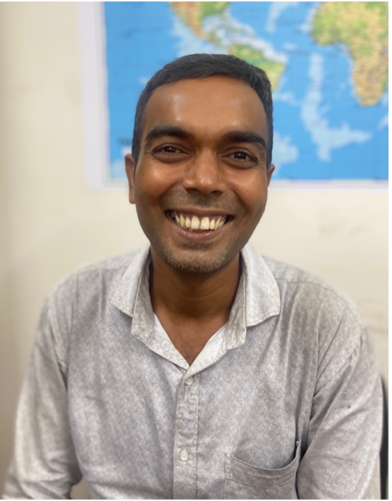A Joyya staff member sitting in an office and smiling at the camera.