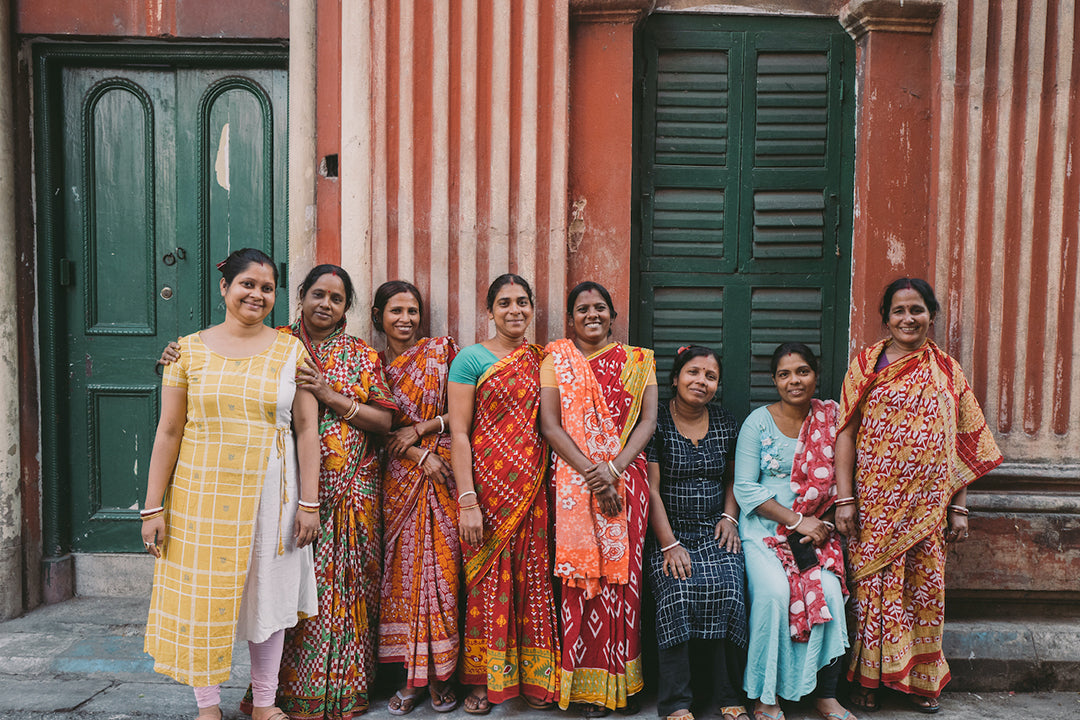 A photo of 8 Joyya staff women sanding side by site in front of a building in Kolkata India