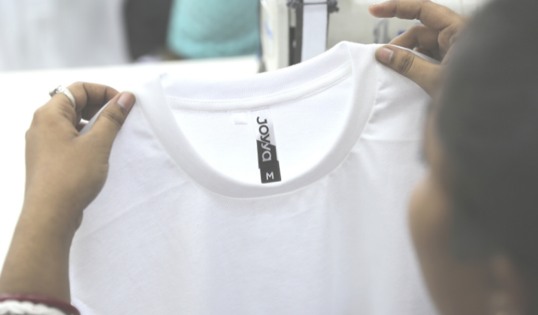 A white fair trade organic cotton t-shirt being held up from the left and right shoulder. 