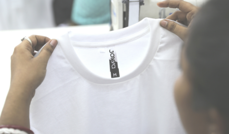 A white fair trade organic cotton t-shirt being held up from the left and right shoulder.