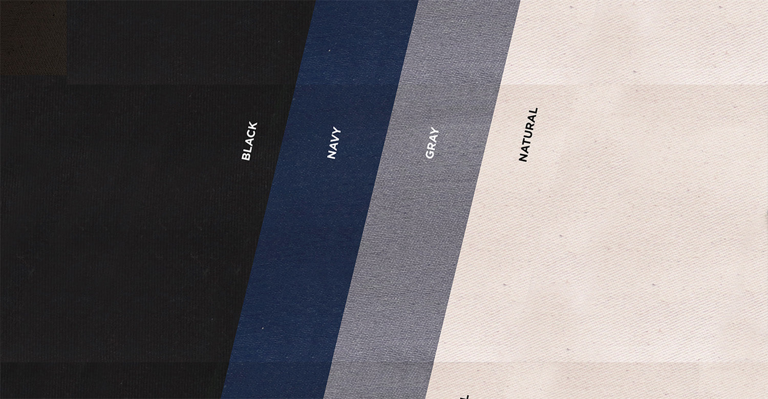 Four colors of organic cotton canvas fabric including black, navy, gray and natural. The fabric swatches are laid one on top of the other at an angle.