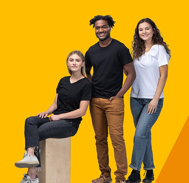 A group of three people, two women and one man wearing black or white fair trade organic t-shirts. One is sitting and two are standing and they are in front of a yellow background. 