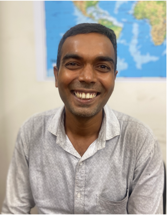A Joyya staff member sitting in an office and smiling at the camera. 