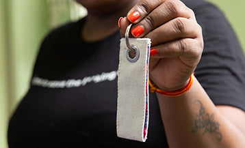 A woman holding up a joyya loop keychain